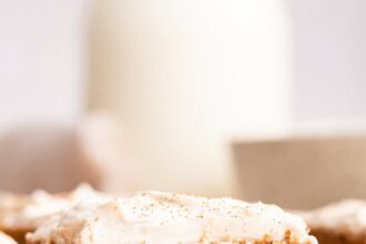 A slice of applesauce cake topped with a cinnamon cream cheese frosting.