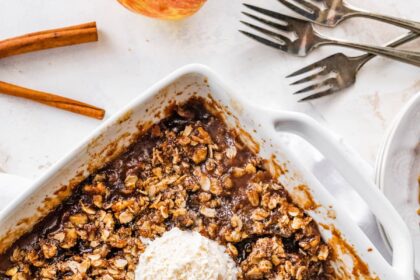 A healthy apple crisp topped with three scoops of ice cream.