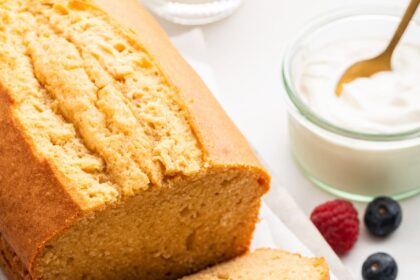 A french yogurt cake loaf with three slices leaning on one another near the loaf.