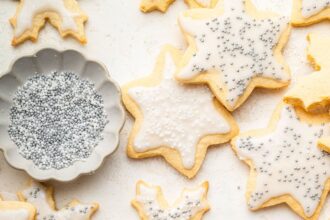 Multiple gluten free sugar cookies decorated with icing and sprinkles.