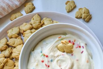 Protein Dunkaroo dip in a white bowl with bunny crackers on the side.